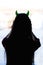 silhouette of woman with devils horns on head