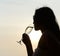 Silhouette of woman drinking