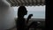 Silhouette of a woman drinking coffee on the balcony of a hotel with a beautiful view of the sea.