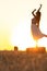 Silhouette woman figure at sunset standing on hay stack, beautiful romantic girl posing outdoors in field, freedom concept