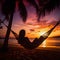 Silhouette of woman in a hammock on the beach watching a spectacular sunset.