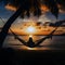 Silhouette of woman in a hammock on the beach watching a spectacular sunset.