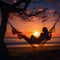 Silhouette of woman in a hammock on the beach watching a spectacular sunset.