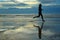 Silhouette of woman jogger running on sunset beach