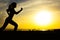 Silhouette of a woman jogging on nature at sunset, sports female profile, concept of sport, leisure and healthcare