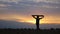 Silhouette of woman jogs with raised flag of Ukraine above head on wheat field. Ukrainian lady running with national