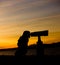 Silhouette of Woman Looking Through Telescope