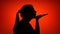 Silhouette of woman making gesture blowing air kiss on red background. Concept of love and romance