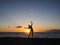 Silhouette woman practicing yoga or stretching on the beach pier at sunset or sunrise. Yoga practice, meditation and