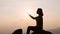 Silhouette of woman praying with faith in religion and belief in god on high mountain where the sun is about to go down