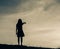 Silhouette of woman praying over beautiful sky background