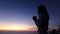 A silhouette of a woman is praying to god as the sun is about to rise.May god protect you and your family.We praise and have faith