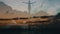 Silhouette of a woman raising arms in front of the ocean at sunset. Girl observes waves raising up in the air and