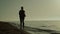 Silhouette woman running beach at sunset. Girl jogging seacoast summer evening.