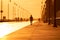 Silhouette of a woman running on a boardwalk at sunset. Long Beach NY