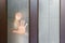 Silhouette of woman`s and child`s hand, palm behind frosted, opaque glass of wooden door. concept of single-parent family. Raisi