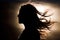 Silhouette of woman\\\'s head with waving hair, back light