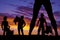 Silhouette of woman\'s legs and three cowboys in the sunset