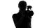 Silhouette of a woman shoots video