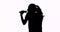 Silhouette of woman singing with microphone
