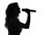 Silhouette of a woman singing with a microphone in hands