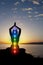 Silhouette of woman sits in a lotus pose on beach sunset view, glowing seven all chakra. Kundalini energy. girl practicing yoga