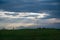 Silhouette of woman standing on meadow and watching castle ruin on dramatic dark cloudy sky