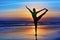 Silhouette of woman stretching at yoga retreat on sunset beach