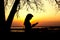 Silhouette of a woman studing the Bible in nature at sunset, concept religion and spirituality