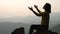 Silhouette woman on sunset background. Woman raising his hands in worship. Christian Religion concept background. Pray to remember