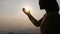 Silhouette woman on sunset background. Woman raising his hands in worship. Christian Religion concept background. Pray to remember