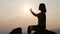Silhouette woman on sunset background. Woman raising his hands in worship. Christian Religion concept background. Pray to remember