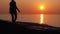 Silhouette of a Woman at Sunset Running along the Seashore