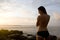 Silhouette of woman in swimsuit watching sunrise