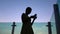 Silhouette of woman using smartphone at sunset on the rooftop of the building