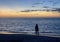 Silhouette of woman wading on a Florida beach after sunset.