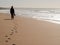 Silhouette of a woman walking alone at the beach