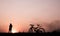 Silhouette of woman walking and biking on the walkway, exercise for health in the evening.