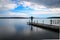 Silhouette of a woman walking on a pier at the lake