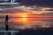 Silhouette of woman walking into the sunrise of lake Bonneville Salt Flats, Wendover, Western Utah, USA, America. Dreamy red