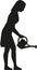 Silhouette of woman watering flowers with can