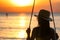 Silhouette woman wear bikini and straw hat swing the swings at the beach on summer vacation at sunset. Girl in swimwear sit