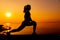 Silhouette woman workout alone with sunset background. Healthy and solo exercise activity. Wellness lifestyle