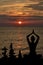 Silhouette of woman in yoga posture and balanced stones