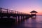 Silhouette of wooden pier with pavilion at the gorgeous dusk