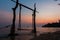 Silhouette wooden swing and calm sea