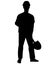 Silhouette of a worker in work clothes and a hard hat standing with a shovel in his hands and preparing to dig a hole