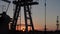 Silhouette of working oil pump from oil field at sunset.The industrial equipment