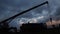 The silhouette of a working truck crane and a special vehicle for servicing oil wells dismantles equipment against the