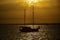 Silhouette of yacht with people travelers in sea against background of beautiful golden sunset. Golden tropical sunset over sea